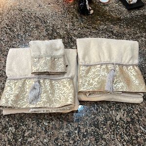 Set of two bath size towels and one washcloth that have tassels and rope trim
